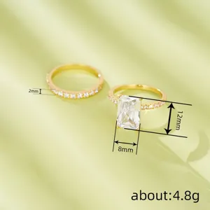 Vista detallada de anillo de oro con piedra talla esmeralda y alianza brillante.