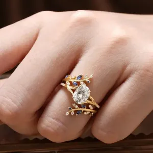 Close-up detail of exquisite leaf vine ring with oval main stone and blue crystal accents.