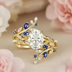 Exquisite gold vine leaf ring featuring an oval center stone, dazzling diamonds and blue stones.