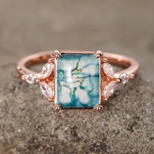 Anillo elegante de ágata musgo con circonitas cúbicas brillantes en acabado de oro rosa.
