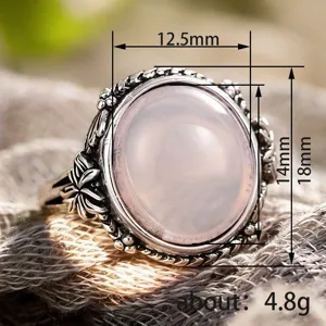 Retro vintage silver flower ring with pink synthetic moonstone cabochon, elegant jewelry piece.