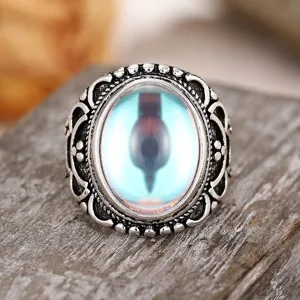 Detailed shot of vintage carved ring with glowing center stone, retro court style fashion jewelry.