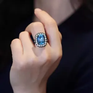 Primer plano de un anillo de estilo gótico chapado en oro negro con piedra de circón azul.
