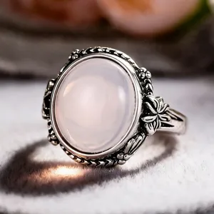 Close-up detail of retro silver-tone floral ring with oval milky simulated moonstone.
