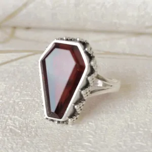 Primer plano detallado del anillo gótico punk de ataúd con gema roja de plata esterlina