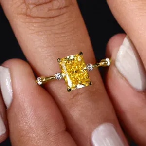 Primer plano de anillo de circonita amarilla con piedras laterales en modelo, lujo elegante.