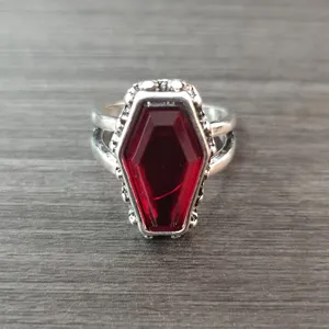 Vista detallada del anillo punk vintage con piedra roja de ataúd y metal gótico.