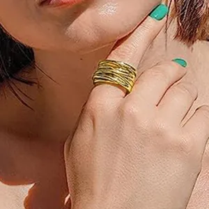Detalle en primer plano del anillo de metal dorado tejido, joya elegante y muy moderna.