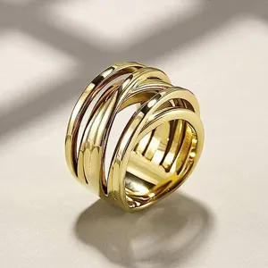 Primer plano detallado de un anillo ancho de metal cruzado de múltiples bandas, estilo hip-hop trendy.