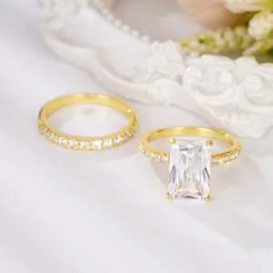 Vista detallada del lujoso conjunto de anillos de circonita talla esmeralda dorada con pavé brillante.