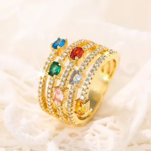 Exquisito anillo multicapa con piedras preciosas ovaladas de colores, primer plano detallado.