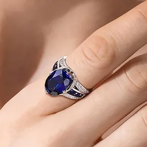 Primer plano detallado del anillo de cóctel de plata con zafiro azul y piedras.