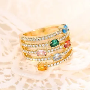 Primer plano detallado del anillo dorado multicapa con piedras de cristal coloridas.