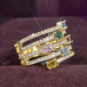 Elegante anillo de oro multicapa con piedras preciosas coloridas y circonitas brillantes.