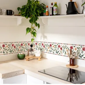 Detalle de adhesivo mural floral de cocina con patrón de cenefa colorida en pared.