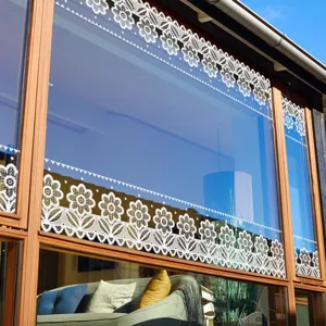 Detail shot of white floral lace window sticker applied on glass, perfect for home decor.