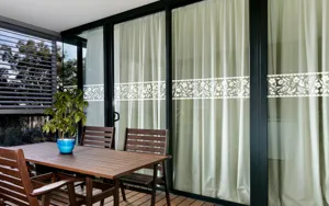 Detail view of white floral decorative window sticker applied on glass sliding door for home.