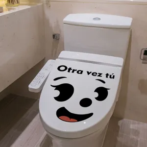 Detail shot of funny Spanish quote toilet lid sticker featuring cute cartoon smiling face design.