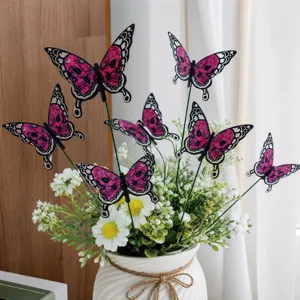Detailed view of Halloween butterfly garden stakes with pink skull patterns in a potted plant.
