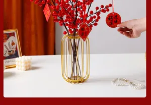 Künstliche Winterbeeren Vasen Detail, goldener Metallrahmen mit roten Beeren für Neujahrsdeko.