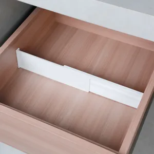 Dettaglio in primo piano del divisorio per cassetti in plastica regolabile nel legno.