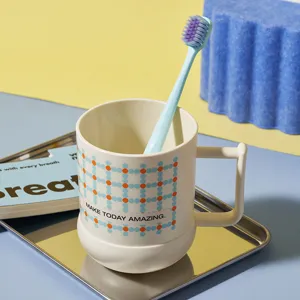 Semplice bicchiere in plastica con spazzolino, design con motivo a pois geometrici per il bagno di casa.