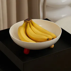 Fruttiera moderna e minimalista con piedi colorati, elegante ciotola decorativa.