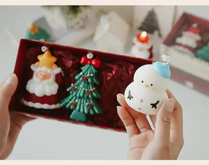 Christmas scented candle gift set detail featuring cute snowman, tree and Santa designs.