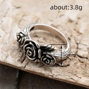 Detailed close-up of vintage silver rose ring, showcasing intricate floral and branch details.