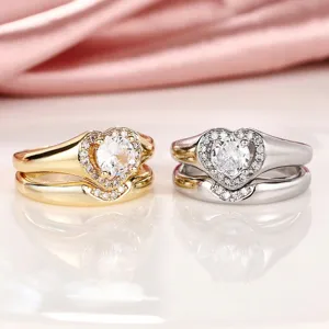 Primer plano detallado de anillos de pareja brillantes en forma de corazón en oro y plata.