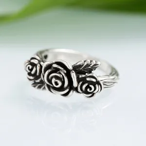 Vintage silver rose ring detail shot, retro distressed floral band design for women's fashion.