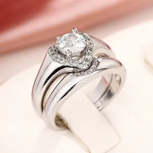 Vista detallada del juego de anillos dobles con piedra central brillante y halo de corazón.