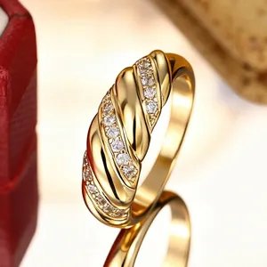 Gros plan sur la bague torsadée en or avec zircon, présentant une élégante texture en spirale.