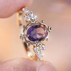 Gedetailleerde close-up van een vintage gouden ring met paarse edelsteen en zirkonia.