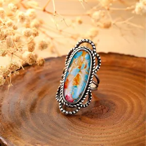 Κοντινό πλάνο δαχτυλιδιού vintage boho με χρωματιστή πέτρα και μεταλλική στριφτή ζώνη.