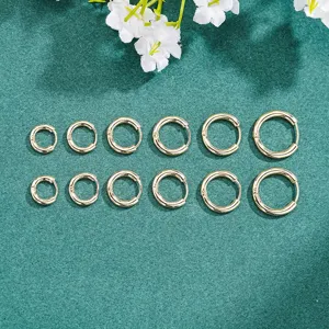 Primer plano de set de pendientes de aro dorados, diseño redondo liso y sencillo.