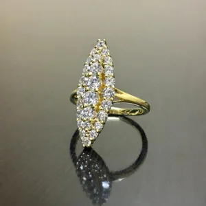 Primer plano detallado de anillo dorado en racimo marquise con circonitas brillantes.