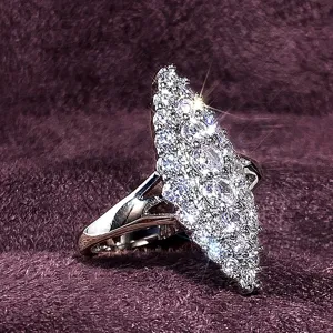 Primer plano detallado de un anillo de coctel brillante con cristales pavé y banda de plata.