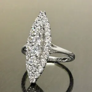 Primer plano detallado de un impresionante anillo de racimo navette con circonitas brillantes.