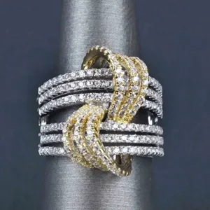 Elegante anillo de dos tonos para mujer con detalles cruzados y brillantes piedras de circonio.
