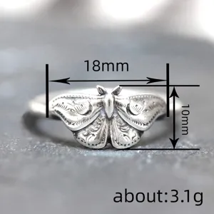 Vintage silver moth ring with carved wing details, retro distressed gothic aesthetic jewelry.