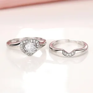 Impresionante anillo de compromiso con corazón y alianza a juego en acabado plateado.