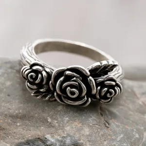 Vintage oxidized silver ring featuring three detailed floral roses and textured band.
