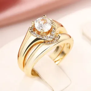 Elegante anillo doble entrelazado dorado con piedra de circonita cúbica brillante.