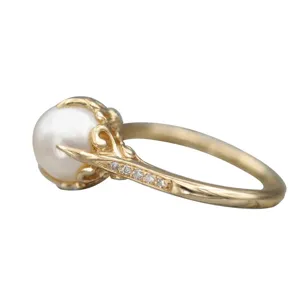 Elegante anillo de perlas doradas con diseño de enredadera delicada y detalles de diamantes.