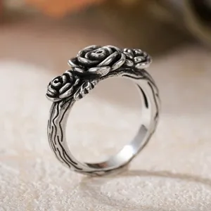 Vintage silver rose ring with detailed branch band, retro rococo style jewelry detail shot.