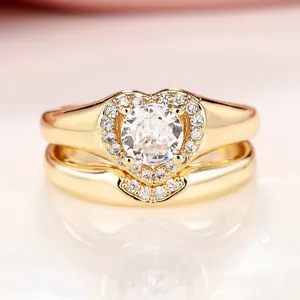 Vista detallada del elegante anillo doble dorado con circonita y halo en forma de corazón.