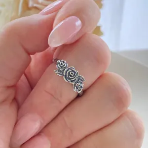 Close-up detail shot of vintage oxidized silver rose flower ring with intricate leaf design.