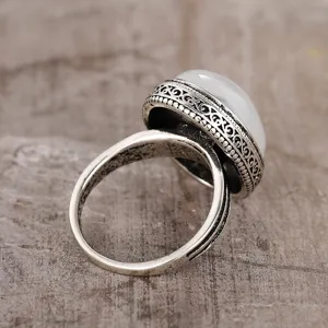 Close-up detail shot of retro silver ring featuring an oval translucent white stone texture.