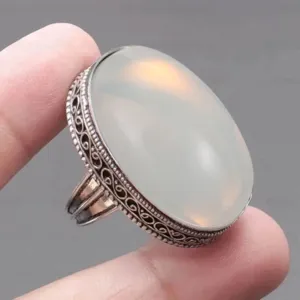 Exquisite vintage oval imitation moonstone ring detail showing ornate filigree silver band design.
